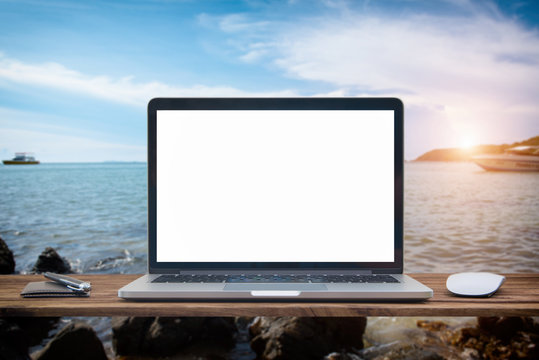 Computer notebook and mouse with a picture Sea view scenery Blur sea background.