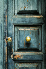Closeup of blue turquoise old textured antique door with gold bronze door handle and keyhole. Vertical.