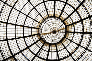 Closeup of a glass roof with metal frame circle and lines. Indoors. Daylight. Background glass graphic architecture elements. Milan, Italy.