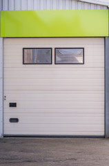 Obraz na płótnie Canvas Weißes Rolltor einer Lagerhalle mit Fenstern