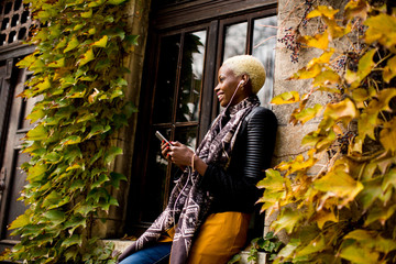 Pretty young black woman with mobile phone