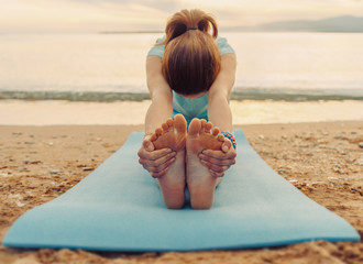 Woman doing yoga exercise on beach