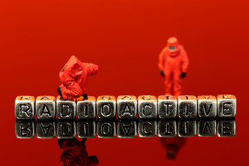 Miniature scale model team in chemical suits with the word radioactive on beads