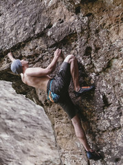 Man free climbing on rock outdoor.