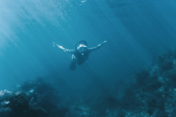 Fototapeta na wymiar Female free diver swimming underwater.