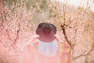 Woman walking in blossoming garden.