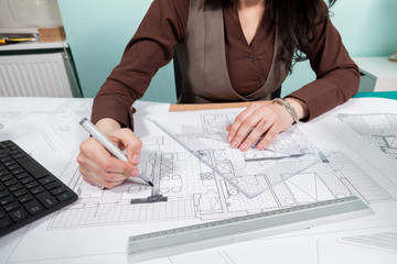 Architect woman at her table working on blueprints. Business and creativity. Architecture job