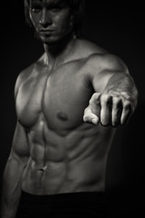 Obraz na płótnie Canvas Portrait of strong healthy handsome Athletic Man Fitness Model posing near dark gray wall