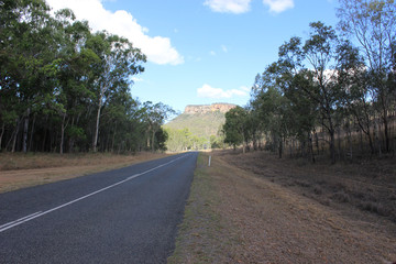 Highway in bush with cliff in the distance