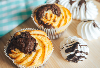 chocolate muffins and cakes on wooden background