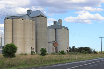 Grain silos from highway and cloudy sky © katrina
