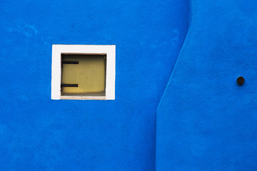 Blue wall of the house with a large window, Burano, Venice