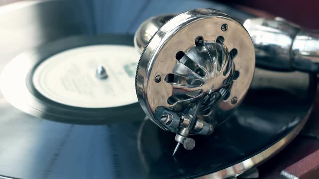Tonearm needle of the old vintage gramophone slides along the track of the retro plate