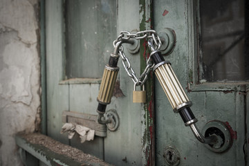 old wooden door locked with a padlock and a chain