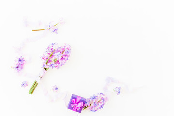 Bouquet of pink flowers, ring box and shabby tapes on white background. Flat lay, top view.