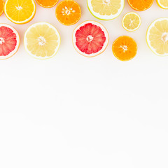 Tasty fruits background. Sliced citrus fruits on white background. Flat lay, top view.