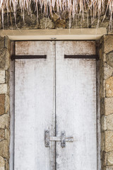 Wooden textured white door with latch, rustic interior in Bali house