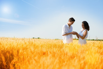 Happy, young couple enjoying in the wheat field, summer season .Sunset light, flare light ,copy space
