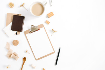 Blogger or freelancer workspace with clipboard, coffee mug, notebook and accessories on white background. Flat lay, top view minimalistic brown styled home office desk. Beauty blog concept.