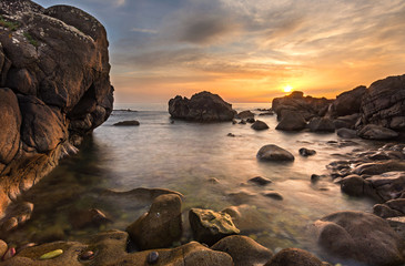 Fototapeta na wymiar Beach with rocks at sunset in atlantic ocean