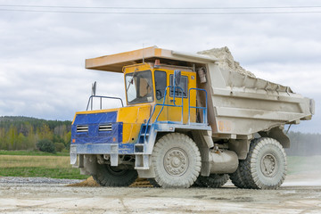 Obraz premium Large-yellow quarry dump trucks produce transportation of minerals