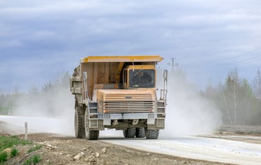 Large-yellow quarry dump trucks produce transportation of minerals