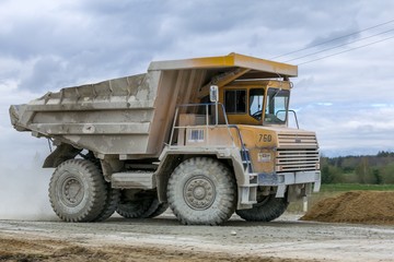 Large-yellow quarry dump trucks produce transportation of minerals
