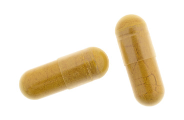 Two turmeric capsules isolated on a white background.