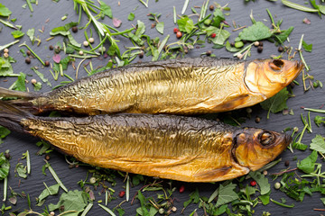 Smoked trout with spices on a stone tray.