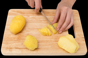 boiled potatoes on board on a black background