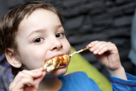 Child eating chicken kebab