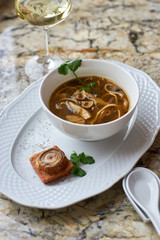 Asian cuisine. Mushroom soup with egg noodles served with toast, bread and white wine on marble background.