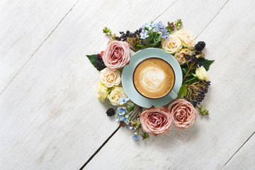 Cappuccino coffee and flowers composition on white wood