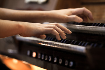 Hands of a woman playing the organ