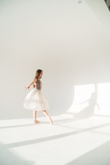 woman with blowed dress by wind. sunny dance studio © sibstock
