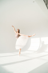 woman with blowed dress by wind. sunny dance studio © sibstock