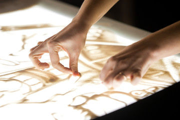 Sand animation. Girl's hands drawing sand closeup  © furtseff