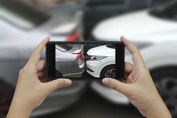 Hand holding smart phone take a photo at The scene of a car crash, car accident.