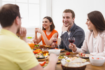 Group of happy people at festive table dinner party