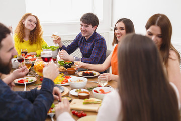 Group of happy people at festive table dinner party