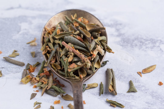 Rhododendron of Adamsia in a spoon on a white background. Dry medicinal tea leaves