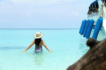 Fototapeta na wymiar Beautiful young woman on the sunny tropical beach relaxing in water