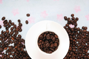 modern white espresso  cup filled with coffee beans over bright background with copy space
