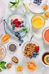 
    Breakfast table with granola, fresh smoothie, juice and various of sandwiches. Healthy eating concept 