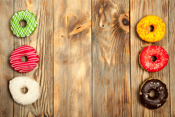 Colorful donuts on wooden background