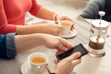 Man and woman enjoying hot beverage in cafeteria