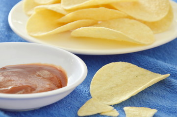 crispy and salt potato chips on dish dipping with tomato sauce