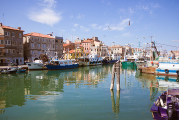 Fishing boats moored in a canal in Chioggia, Italy.