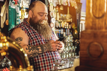 Happy bearded man watching at cellphone