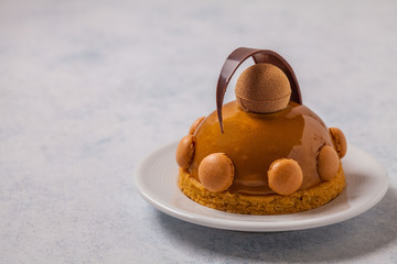 Cake of mousses and caramel on a gray background, horizontally